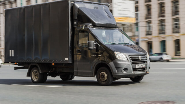 Gazelle rides on the road. Black cargo van GAZ Gazelle Next driving in the street.