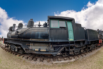 Fototapeta na wymiar Train engine on tracks black with green door