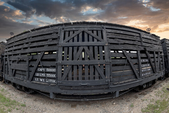 Old Boxcar On Rail Tracks At Sunset