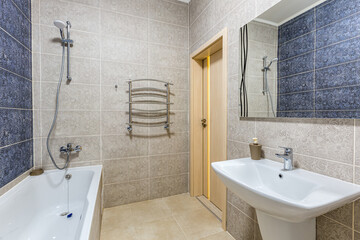 bathroom with shower, bathtub and light tiles