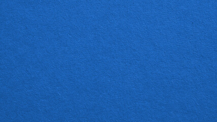 The surface of blue cardboard. Paper texture with cellulose fibers. Background with bright expressive tint. Paperboard wallpaper. Textured backdrop. Top-down. Macro