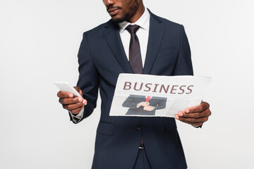 cropped view of african american man in suit using smartphone while holding business newspaper isolated on grey