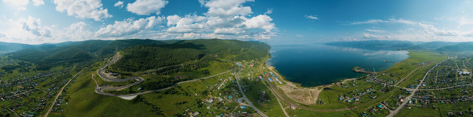 Fototapeta premium Panoramic view of Lake Baikal and serpentine road - aerial view of natural mountain valley with serpantine road, Trans-Siberian Highway, Russia, Kultuk, Slyudyanka. Panoramic view.