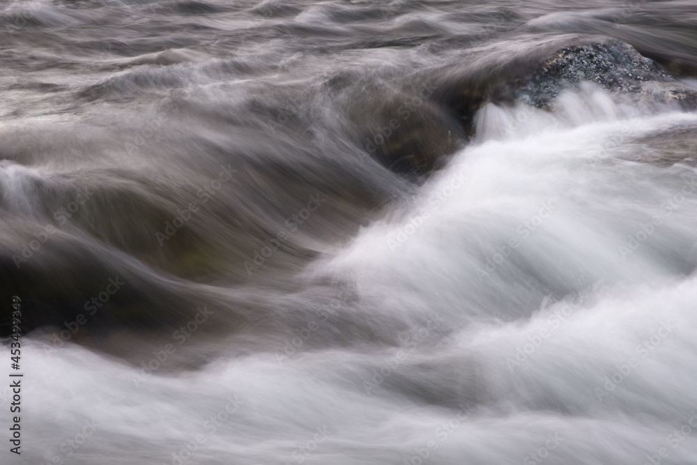Poster abstract background from long exposure of water stream in a mountain river close-up