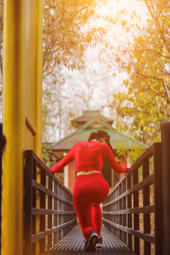 Blurred image,A young woman in sportswear, standing, warms up in the morning to relax her leg and foot muscles so that she can run. The concept of running enthusiasts to prepare for the race.