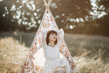 Harmony with nature, meditation, calm and ethnic people. Young relaxed ethnic indian woman sitting...
