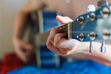Guitarist takes chords on an acoustic guitar.Closeup