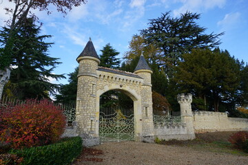 Fototapeta na wymiar unusual fancy gated stone entrance intricate metal fence castle like countryside fall france