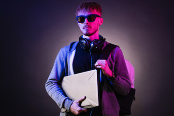 Neon portrait of a bearded man wearing headphones on the neck, parka, backpack, mate sunglasses...
