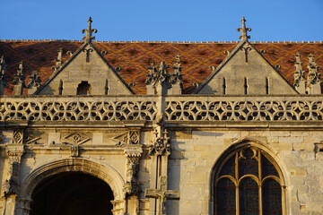 Obraz premium closeup facade old stone church intricate carvings colorful mosaic roof france