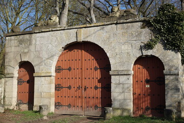 Fototapeta na wymiar old stone gate and red wood doors france