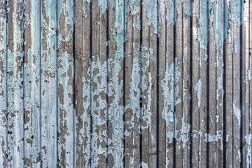 Texture of a painted wall with cracks and peeling paint as a background.