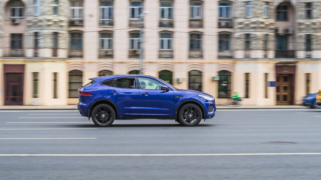 Jaguar E-Pace X540 is driving on high speed in front of classic vintage building
