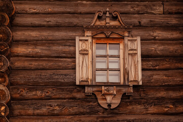 Traditonal russian wooden log house with carved window shutters