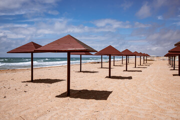 A beautiful sandy beach with an umbrella that casts a harmonious shade.