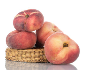 Several juicy organic peaches with a straw stand, close-up, isolated on white.