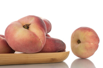Several juicy organic peaches with bamboo dish, close-up, isolated on white.