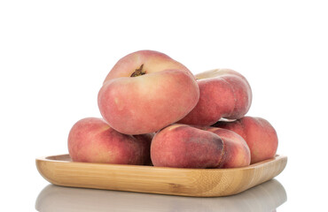 Several juicy organic peaches with bamboo dish, close-up, isolated on white.