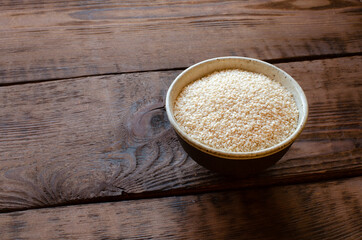 sesame in clay bowl on wooden background
