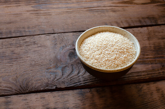 sesame in clay bowl on wooden background