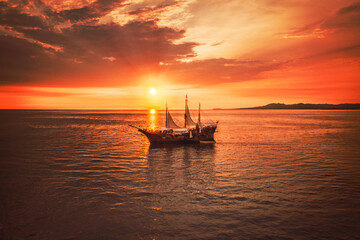 Pirate boat with a beautiful sunset as the background, the boat name is Marigalante and Iconic ship...