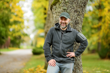 Portrait of an attractive middle age man in beautiful autumn park.