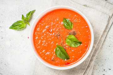 Tomato soup with basil. Summer cold vegan dish. Top view at white background.