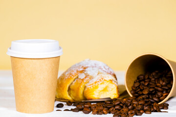 Coffee to go in paper eco cup with almond croissant and coffee bean on wooden and light orange background, Fast food, Copyspace