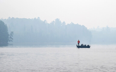 People are fishing and boating at Crane Lake, Voyageurs National Park, in smoke from wildfire 