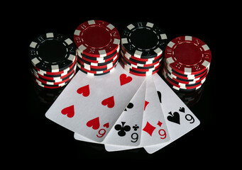 Obraz premium Poker game with four of kind combination. Chips and cards on the black table. Successful and maximum win