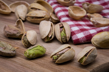 Pistachio nuts on a wooden board, open and ready to eat