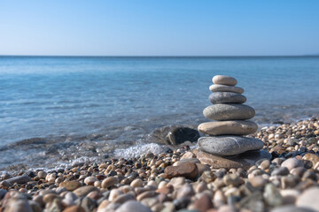 stone tower on the beach and sea background, pebble pyramid,