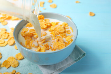 Crispy cornflakes with milk for breakfast on a colored background close-up.