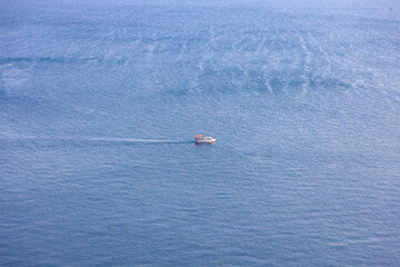 A landscape with a boat floating in Sevan lake at daytime