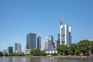 Fototapeta na wymiar Outdoor sunny view of cityscape and promenade of riverside Main river in Frankfurt, Germany during sunny day.