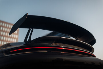 Big carbon spoiler wing on the trunk of modern supercar - obrazy, fototapety, plakaty
