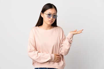 Young Chinese girl over isolated white background having doubts