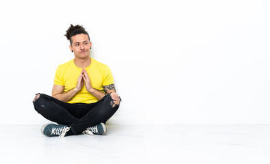 Caucasian man sitting on the floor scheming something