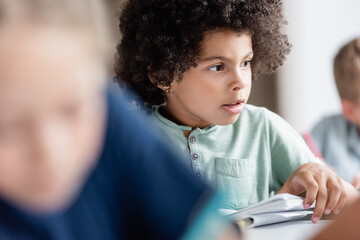 african american boy looking away near blurred pupils © LIGHTFIELD STUDIOS