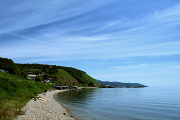 Fototapeta na wymiar Baikal Lake in summer day. Focus on clear transparent water and coastal stones. Summer travel.