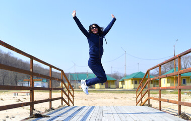 Fototapeta na wymiar Cheerful 45 y.o. Russian woman jumping and laughing
