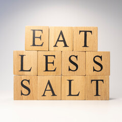 The word eat less salt was created from wooden cubes. Health and life concept,