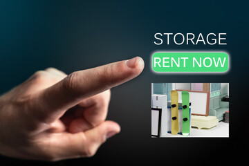 Storage rent now logo. Hand next to Storage rent logo. Personal belongings in storage container. Finger presses rent now button. Warehouse for safekeeping. Warehouse space for personal items