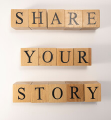 The word Share your story was created from wooden cubes.