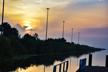 Fototapeta na wymiar Reflections of a swamp sunrise at the dock