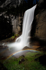Fototapeta na wymiar ainbow and Flowing Waterfall Cascading Summer Mountain Rocks in Yosemite National Park California Green Grass and Landscape Colorful Shines Bright Sun Mist Using Long Exposure. Nature and Flowers Pic