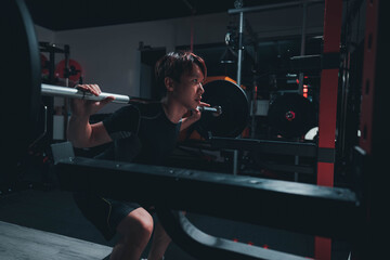 man doing squat in the gym