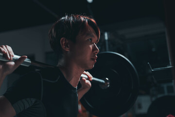 man doing squat in the gym