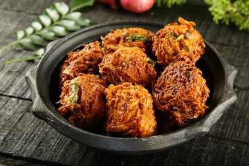 Crispy fried onion fritters, ulli vada, Pyaaz Pakoda  - Indian street foods background.