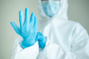 Unrecognizable specialist doctor dress up a medical PPE suit before working in hospital. 